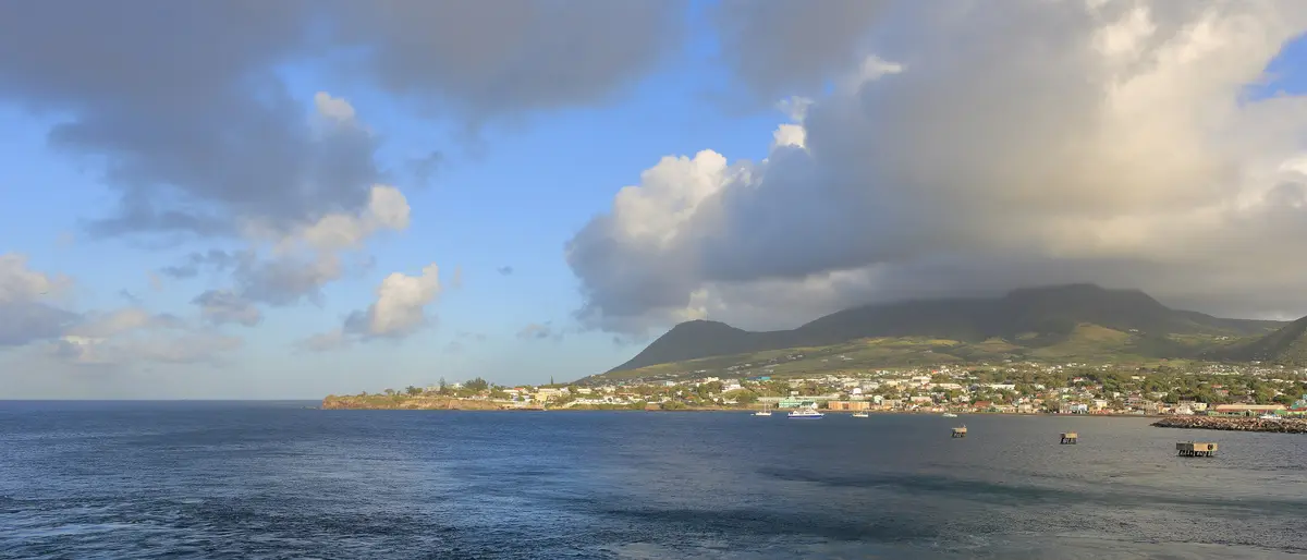 St Kitts at dawn, its green mountains under low cloud, seen from a ship entering the port of Basseterre